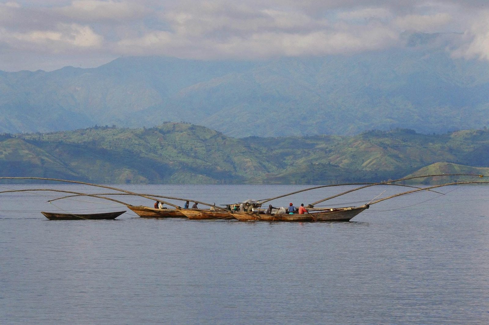 Fishermen in traditional boats on Lake Kivu beneath green hills, eastern Congo