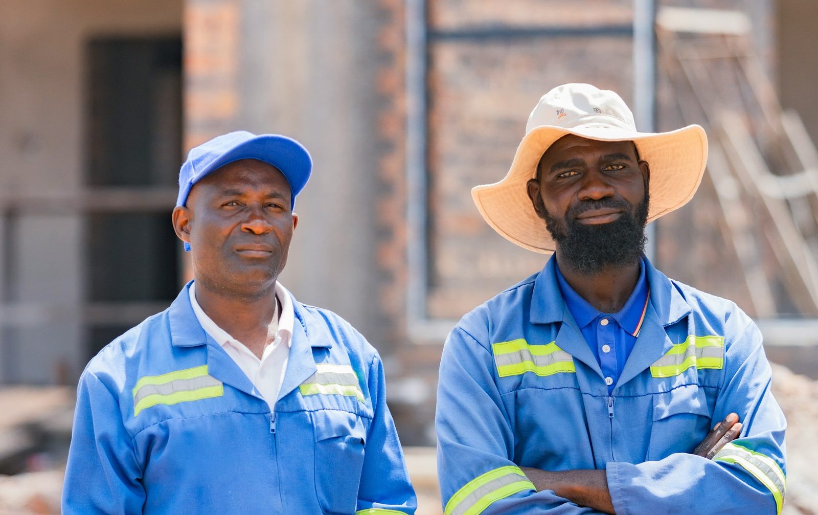 Two African site security officers in blue uniforms at a construction site
