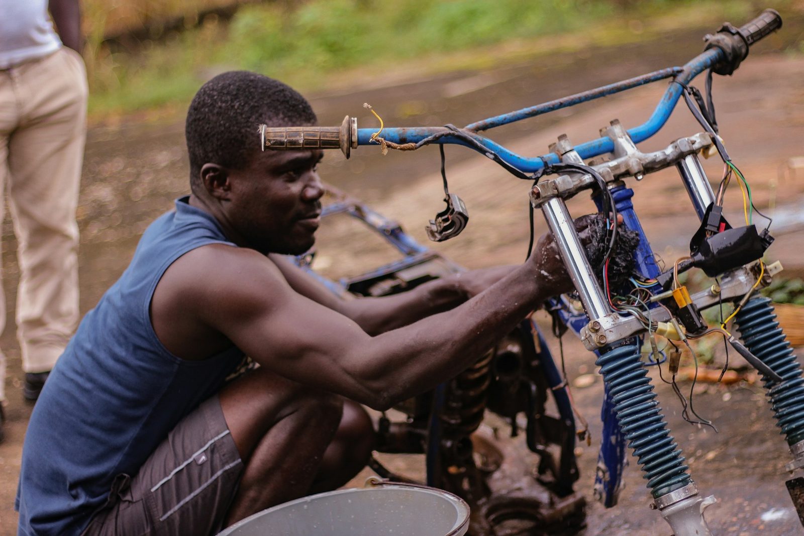 Young African mechanic repairing a motorcycle, learning hands-on technical skills
